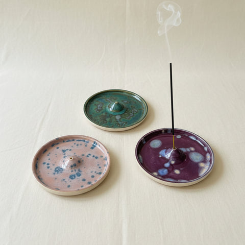 Three ceramic incense burners with speckled patterns on a wooden surface