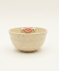 Ceramic bowl with face on a wooden table