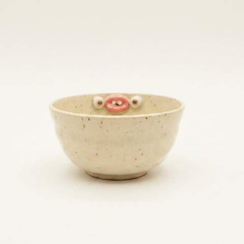 Ceramic bowl with face on a wooden table
