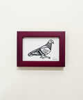 Framed illustration of a bird on a wooden surface