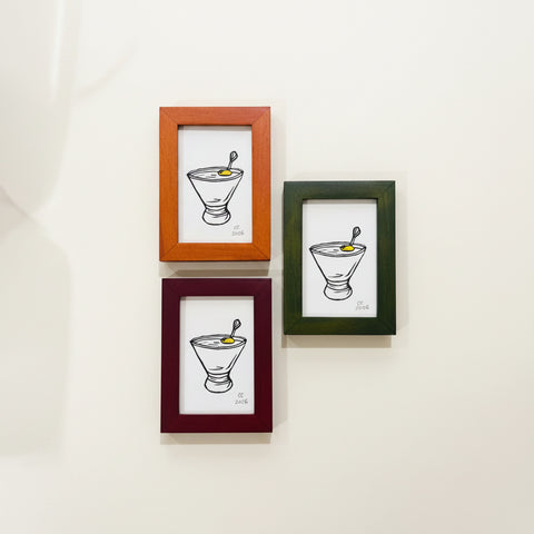 Three framed illustrations of a bowl with a spoon on a wooden surface