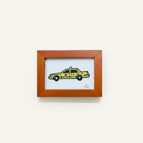 Framed artwork of a yellow taxi on a white background