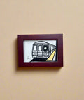 Framed artwork of a train on a wooden surface