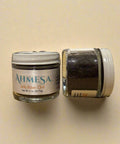 Two jars of Ahmesa salt on a wooden surface