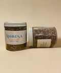 Two jars of Ahmesa Za'atar Mulalal on a wooden surface.