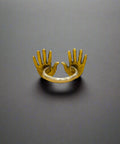Brass ring with a unique design on a wooden surface