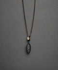 Necklace with a pine cone pendant on a wooden surface