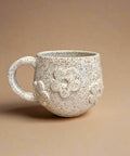 Speckled ceramic mug with floral design