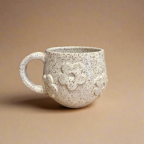 Speckled ceramic mug with floral design