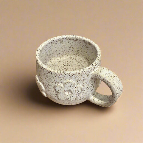 Speckled ceramic mug with floral motif