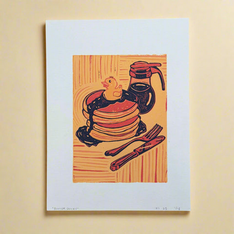 Woodcut-style illustration of pancakes with syrup, a fork, and knife on a wooden surface.