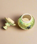Green ceramic jar with bee design