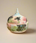 Decorative ceramic pot with lid featuring a bee design.