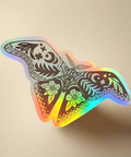 Holographic butterfly sticker on a tan surface