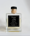 Clear glass diffuser bottle with black label featuring 'Tribe & Oak' on a white background