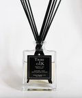 Tribe of Oak diffuser bottle with black sticks on a white background