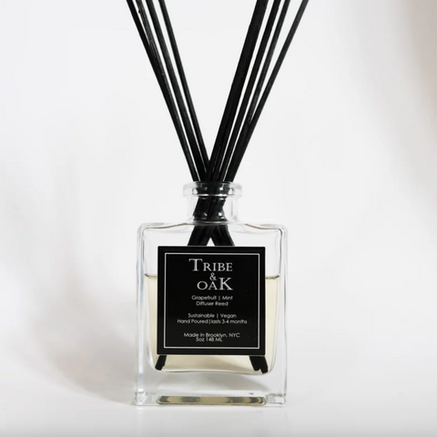 Tribe of Oak diffuser bottle with black sticks on a white background