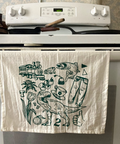 White towel with black illustrations hanging on a stove handle
