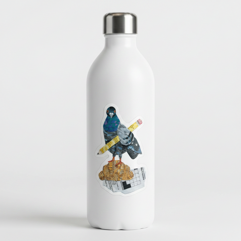 A die-cut sticker featuring a collage-style pigeon holding a yellow pencil, standing on a newspaper, photographed on a plain light background.
