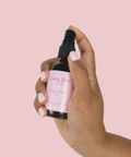 Hand holding a bottle labeled 'Fairy Vibes' against a white background