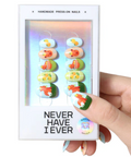 Hand holding a box of press-on nails with 'Never Have I Ever' text