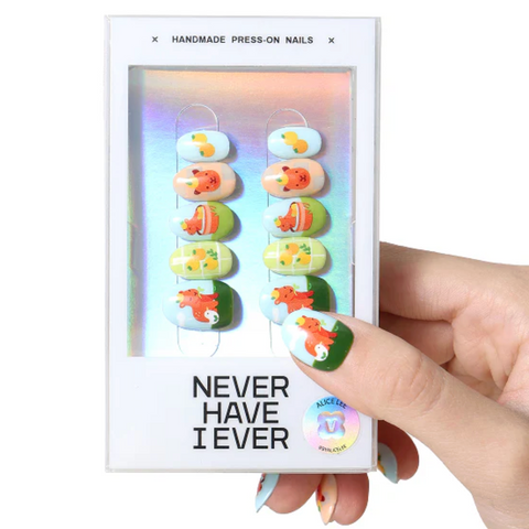 Hand holding a box of press-on nails with 'Never Have I Ever' text