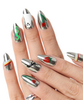 Hand with silver and green nail art on a white background