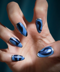 Hand with blue nail polish on a dark background