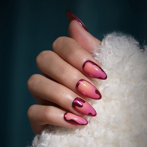 Hand with pink and red gradient nail polish on a white textured surface
