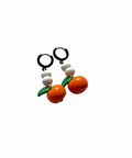 Pair of earrings with orange and green design on a light beige background