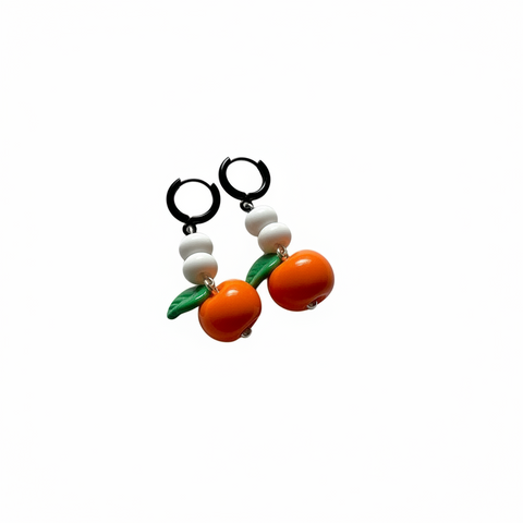 Pair of earrings with orange and green design on a light beige background