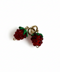 Pair of raspberry-shaped earrings on a beige background