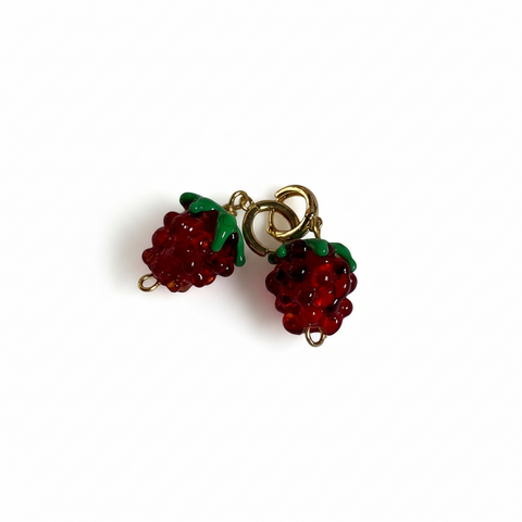 Pair of raspberry-shaped earrings on a beige background