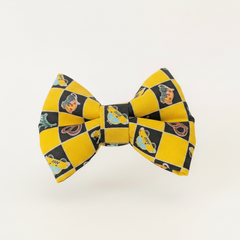 Yellow and black checkered bow tie on a wooden surface