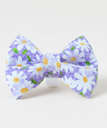 Floral bow tie on a wooden surface with a light gray background