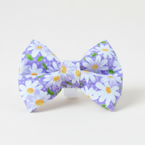 Floral bow tie on a wooden surface with a light gray background