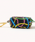 Multicolored patterned pouch with a gold clip on a light wooden surface