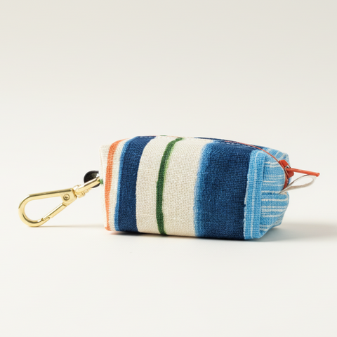 Striped pouch with a carabiner on a light wooden surface