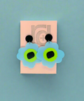Flower-shaped earrings on a pink card with a visible brand logo.