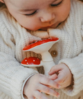 Baby holding a red and white mushroom-shaped toy