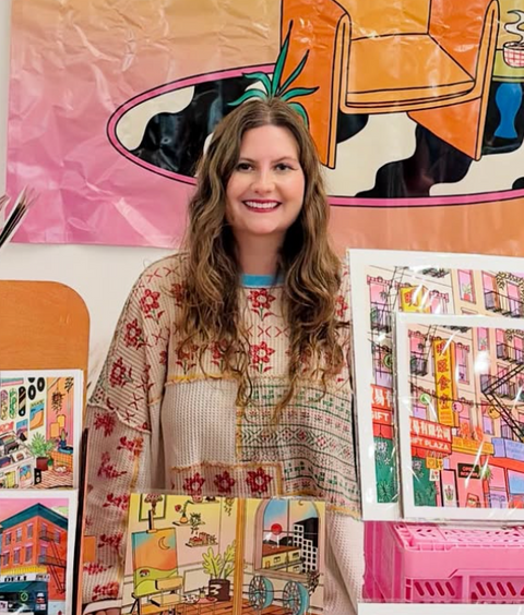 Woman standing in front of a wall with colorful art prints and a large illustration of a chair.