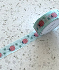 Roll of decorative tape with ladybug pattern on a speckled surface