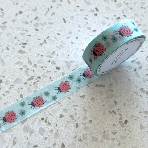 Roll of decorative tape with ladybug pattern on a speckled surface