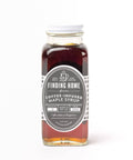 Bottle of Finding Home Farms coffee-infused maple syrup on a white background