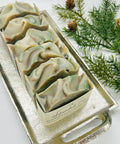 Decorative soap bars in a silver mold with greenery on a white background