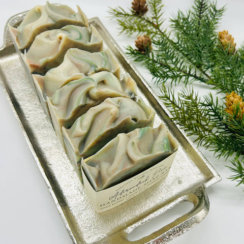 Decorative soap bars in a silver mold with greenery on a white background