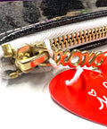Close-up of a pouch with a gold zipper and a red tag with white text.