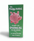 The Pudgy Rabbit Plumpy Pig Crochet Kit for Beginners in its green packaging box, featuring a pink crocheted pig illustration on the front.