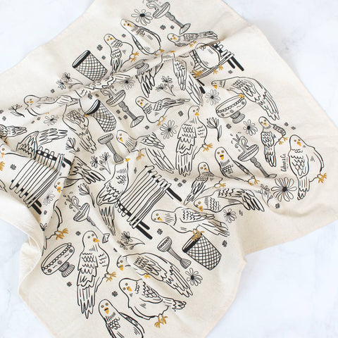 Beige towel with black and gold bird pattern on a white background