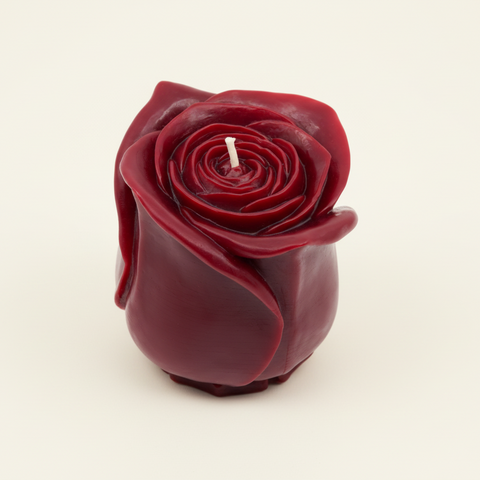 Red rose-shaped candle on a white background